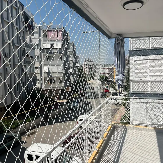 Apartman balkonuna boydan boya uygulanmış balkon filesi
